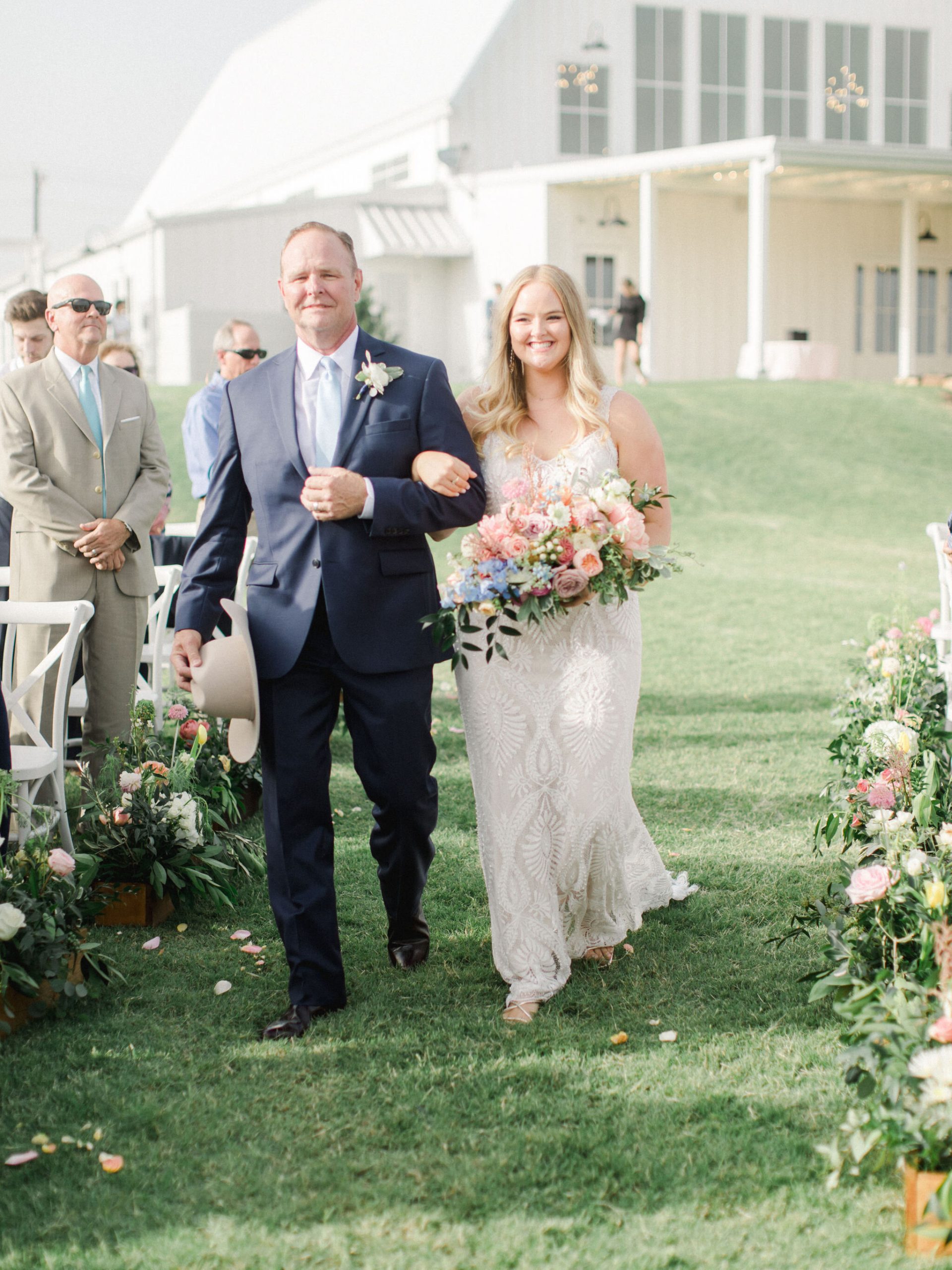 bride walking with father down aisle outside
